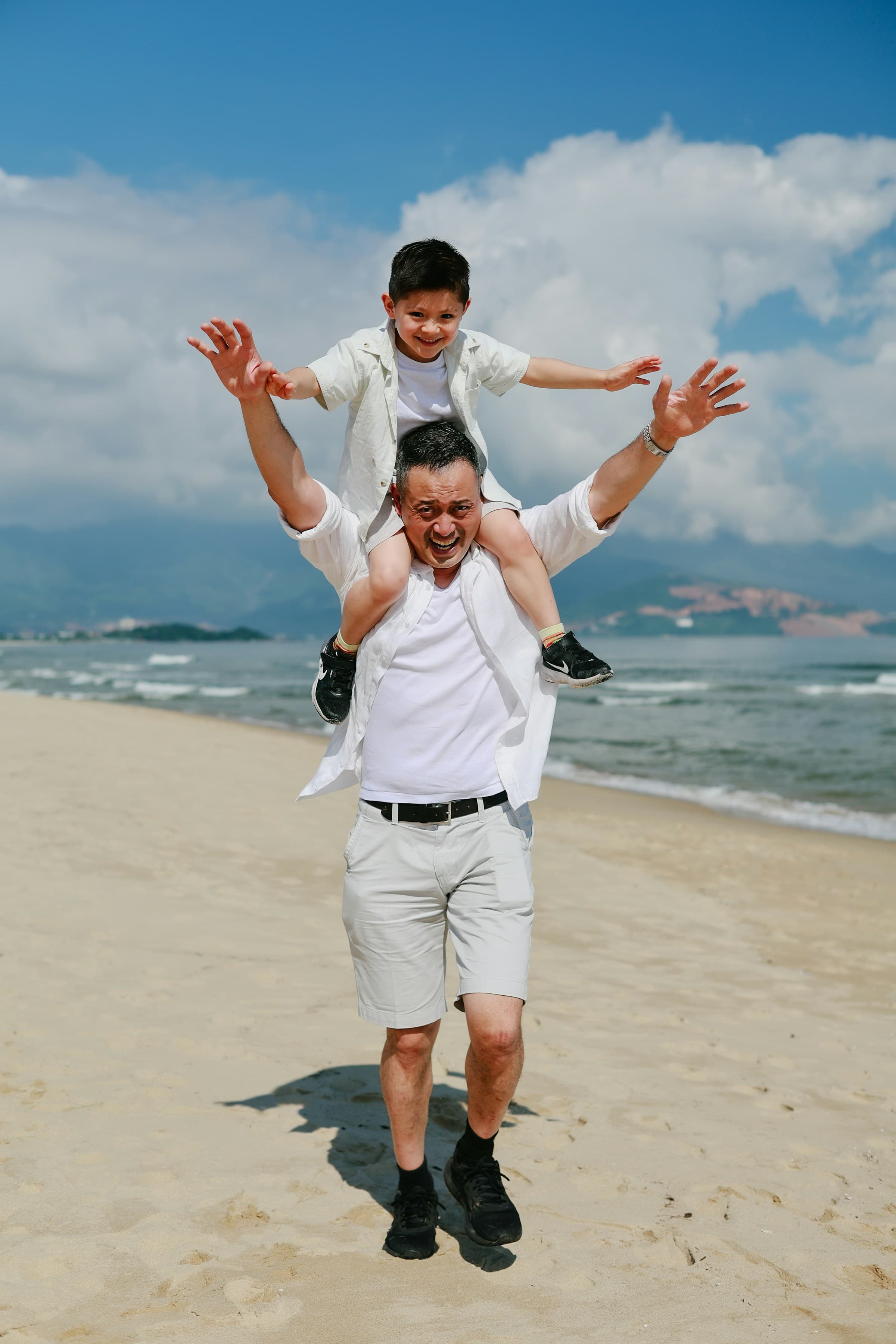 Father and child smiling together on a beach